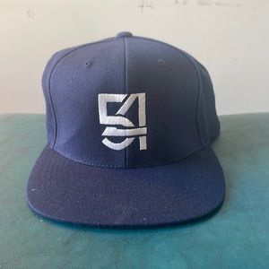Solid navy blue snapback. #54 in the center of hat. Green inside.